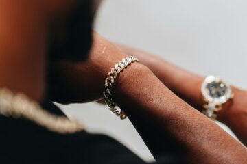 a close up of a person's hand with two rings